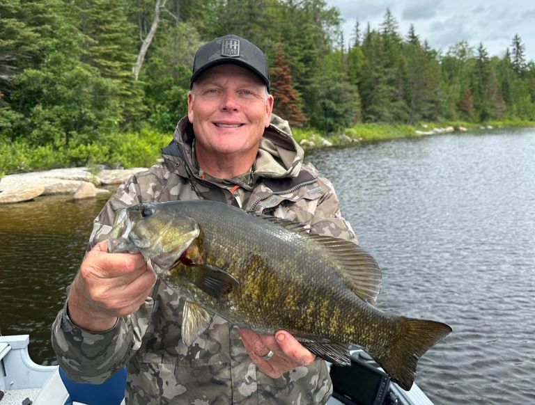 Who's smile is bigger, the guest or the fish?