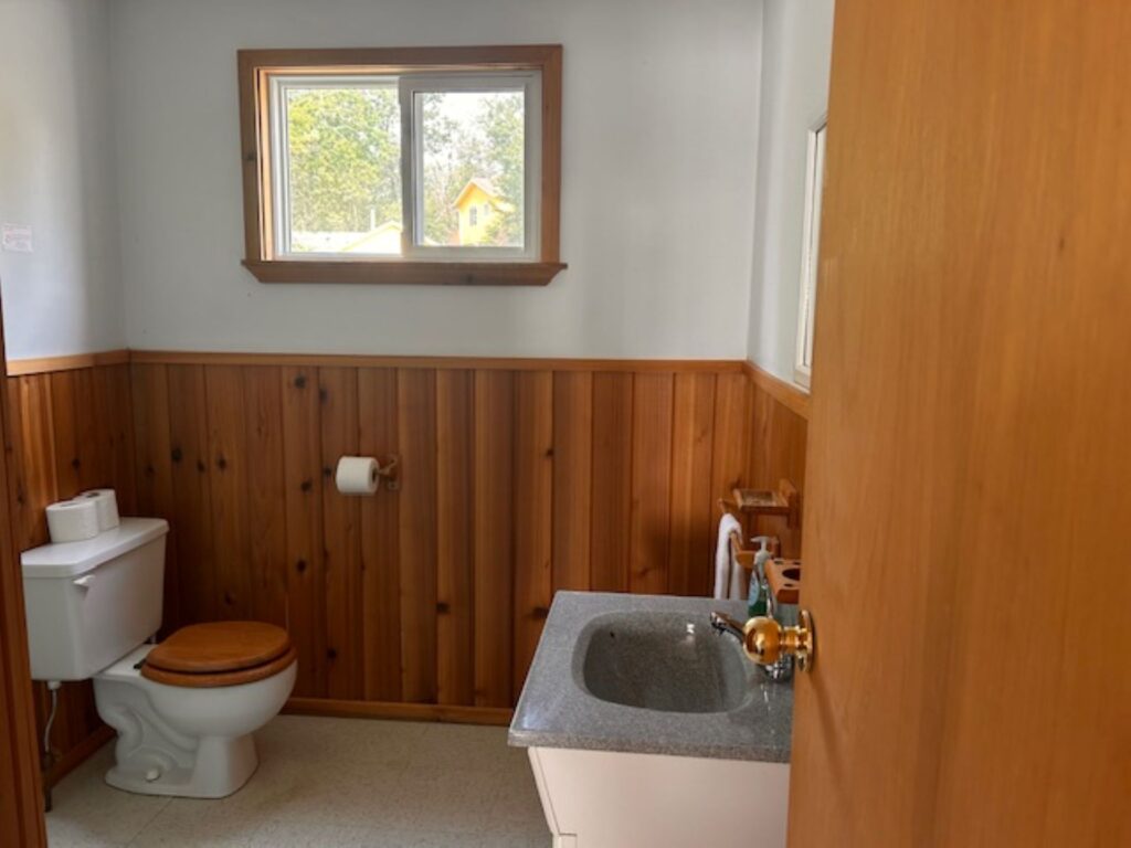 Bathroom in a fisherman's cabin showing a toilet and vanity
