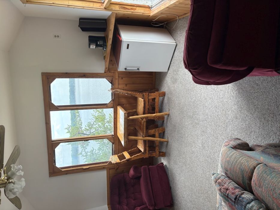 Sitting room with lake views that has a table and chairs, fridge, 2 chairs and a couch