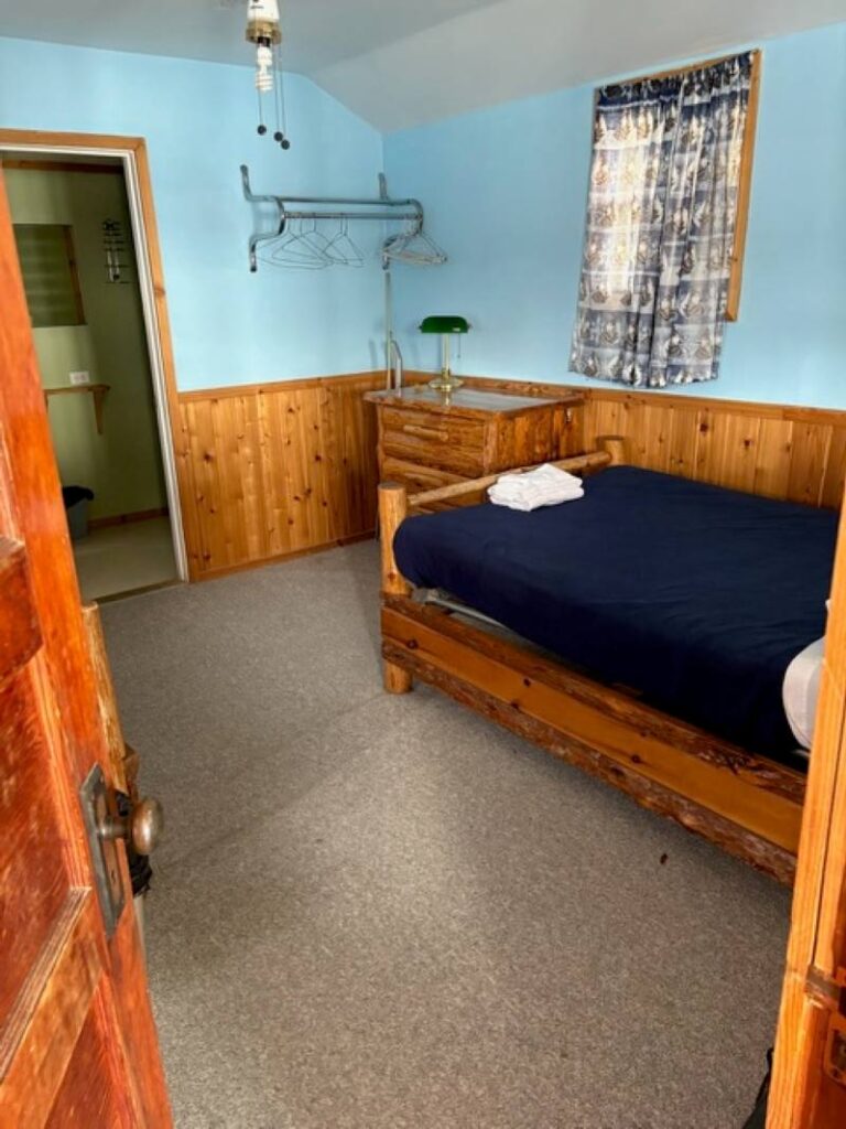Bedroom in a rental cabin with blue walls and navy comforter on the bed
